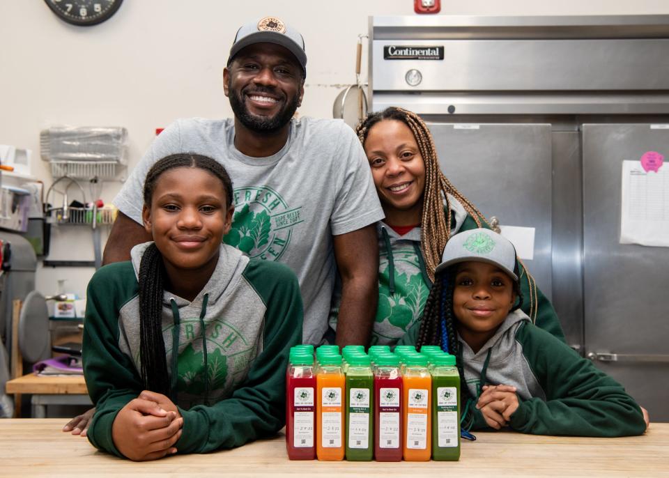 Donte and Adrienne King, owners of So Fresh So Green Juice Co., pose with their daughters, Brielle and Camille, in front of a fresh batch of juice they pressed and bottled together on Wednesday, February 2, 2022.