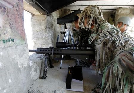 A sniper and spotter look out over the border in the Kitton outpost along the border fence on the border with Afghanistan in North Waziristan, Pakistan October 18, 2017. REUTERS/Caren Firouz