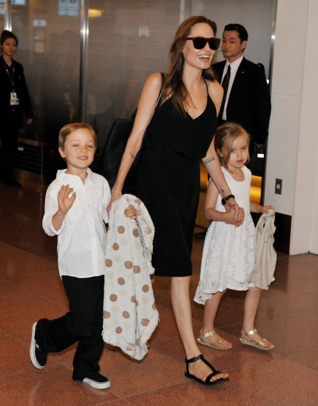Angelina Jolie (C) and children Knox (L) and Vivienne arrive at Tokyo International Airport in Tokyo, Japan on June 21, 2014. On August 3, 2008, People magazine published the first photos of the newborn twins after paying up to $14 million, the most ever paid for baby pictures. File Photo by Keizo Mori/UPI