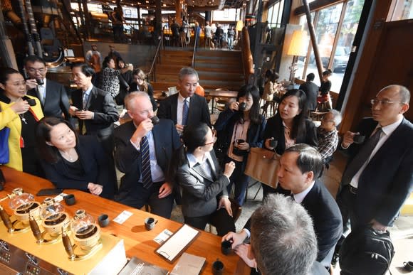 Starbucks CEO Kevin Johnson drinks coffee with Chinese delegation a roastery store.