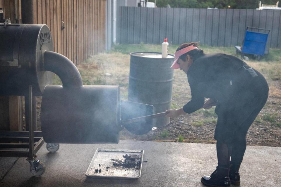 Pitmaster Cecilia Guerrero tends the fire of the smoker at Goldee’s Barbecue in Fort Worth on Saturday, April 22, 2023.