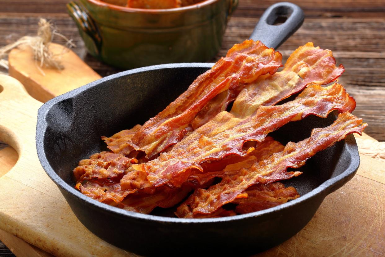 hot fried bacon pieces in a cast iron skillet