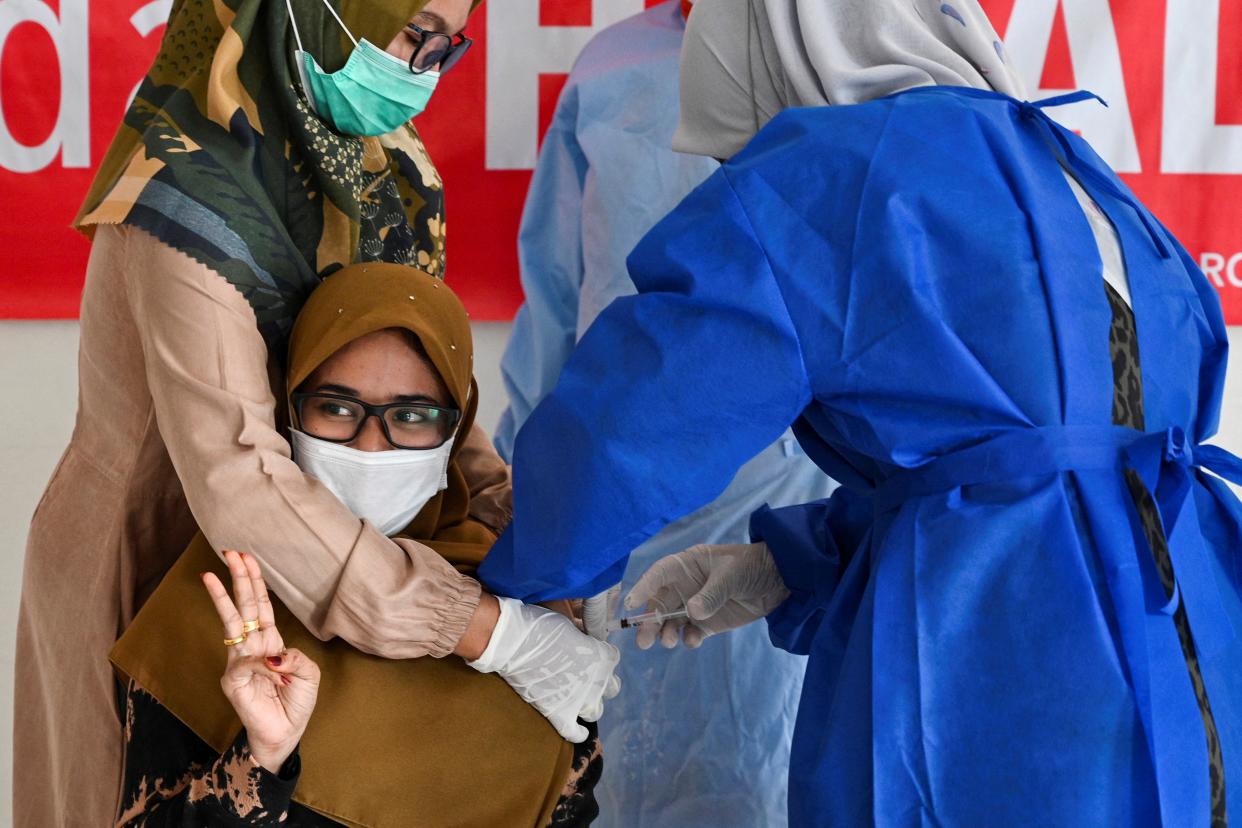 TOPSHOT - A woman receives a dose of the Moderna Covid-19 vaccine, donated to Indonesia by the US, during a booster vaccination drive in Barona Jaya on the outskirts of Banda Aceh on August 13, 2021. (Photo by CHAIDEER MAHYUDDIN / AFP) (Photo by CHAIDEER MAHYUDDIN/AFP via Getty Images)