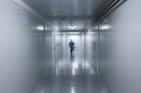 FILE - In this April 16, 2020, file photo, a worker wearing protective gear walks down the corridor of a new health facility that will take in patients infected with the new coronavirus, during a media presentation in Panama City. Even amid a global pandemic, there’s no sign that corruption is slowing down in Latin America. From Argentina to Panama, a number of officials have been forced to resign as reports of possibly fraudulent purchases of ventilators, masks and medical supplies proliferate. (AP Photo/Arnulfo Franco, File)