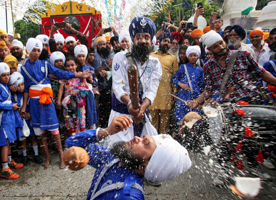 <p>Eine Gruppe von Sikhs zelebriert bei einem Festival die Yoga-Kampfkunst Gatka. Dabei wird eine Kokosnuss zerschlagen, die auf dem Mund eines Gläubigen ruht. (Bild: Reuters/Munish Sharma) </p>