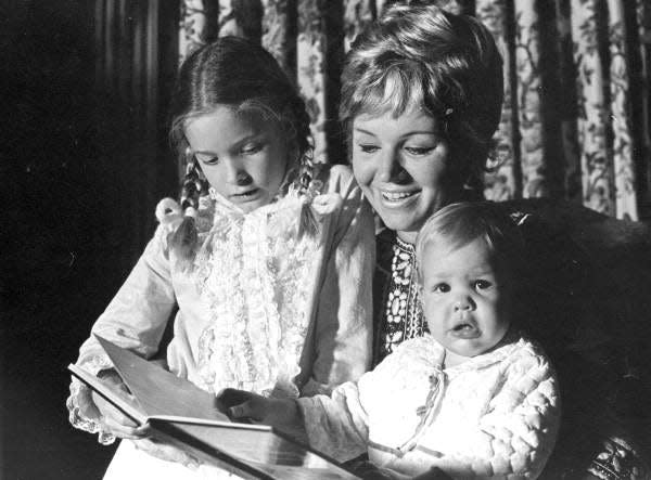 Erika Mattfeld Kirk reads a book to her daughters Adriana Dolabella and Claudia Kirk in December 1969.