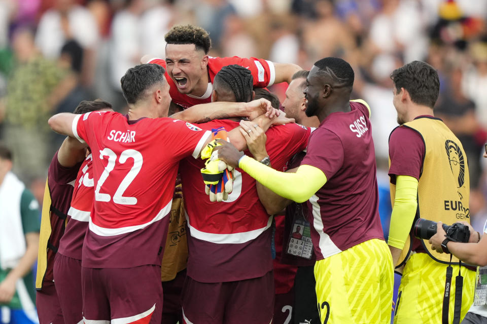 Switzerland players embrace after a round of sixteen match between Switzerland and Italy at the Euro 2024 soccer tournament in Berlin, Germany, Saturday, June 29, 2024. (AP Photo/Ebrahim Noroozi)