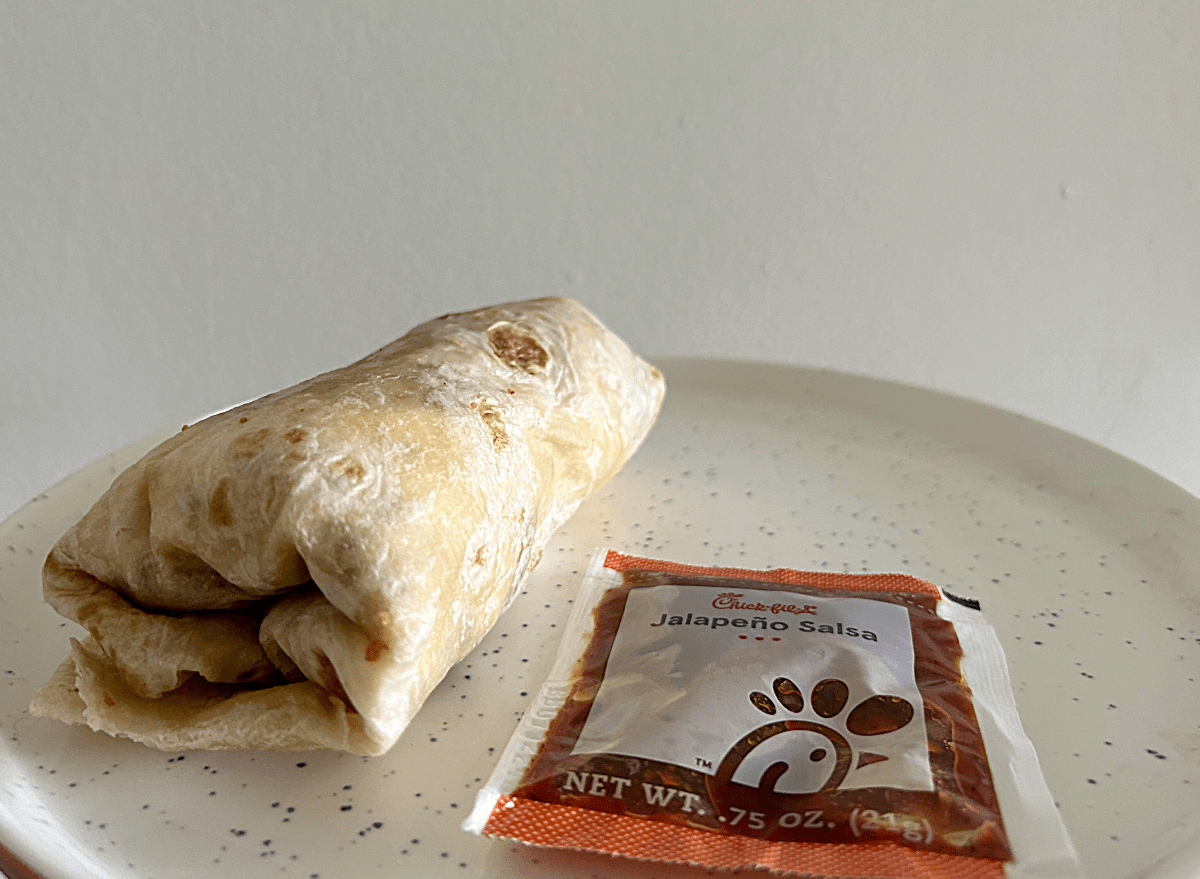 a chick-fil-a breakfast burrito on a white speckled plate. 