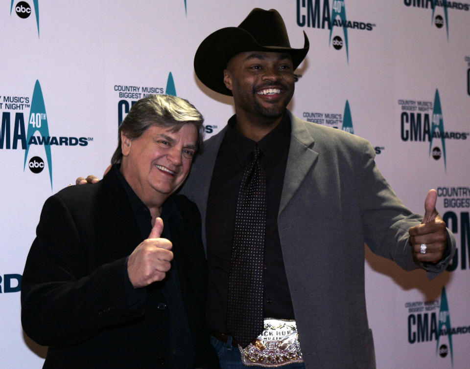 FILE - In this Nov. 6, 2006 file photo, Phil Everly, left, and Cowboy Troy arrive at the 40th Annual CMA Awards in Nashville, Tenn. Everly, who with his brother Don formed an influential harmony duo that touched the hearts and sparked the imaginations of rock 'n' roll singers for decades, including the Beatles and Bob Dylan, died Friday, Jan. 3, 2014. He was 74. Everly died of chronic obstructive pulmonary disease at a Burbank hospital, said his son Jason Everly. (AP Photo/Chitose Suzuki, File)