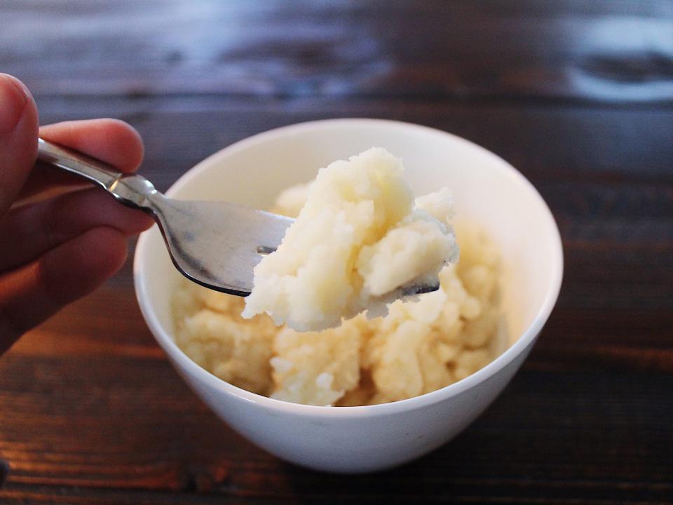 bells mashed potatoes in a white bowl with fork