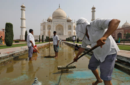 Labourers clean the fountain in the historic Taj Mahal premises in Agra, India, May 19, 2018. Picture taken May 19, 2018. REUTERS/Saumya Khandelwal