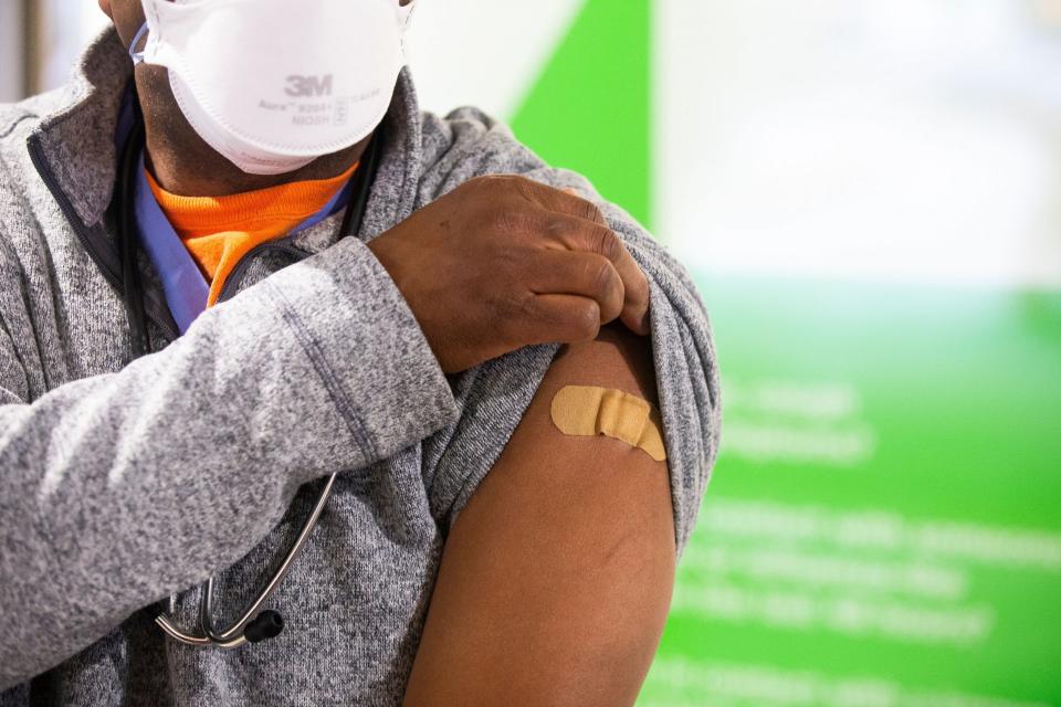 Mandatory Credit: Photo by MICHAEL REYNOLDS/EPA-EFE/Shutterstock (11545483a)Anesthesiologist Raymond Pla shows where the needle went into his arm after being vaccinated with the Pfizer-BioNTech COVID19 vaccine, at a press event at George Washington University Hospital in Washington, DC, USA, 14 December 2020.