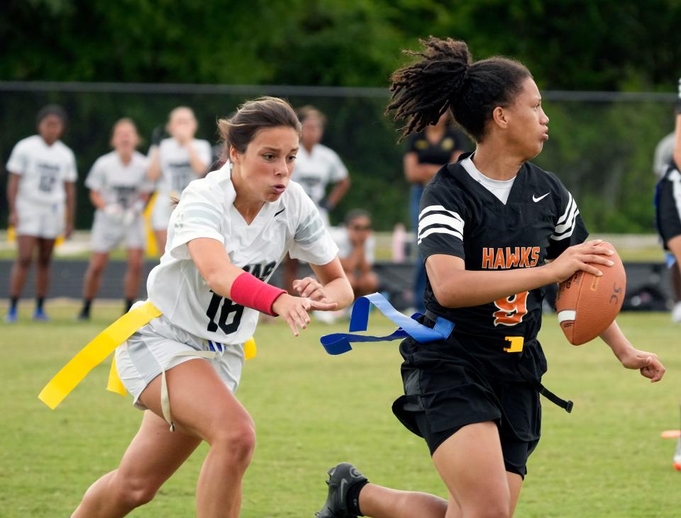 Spruce Creek QB Anastasia Neal (9) attempts to elude New Smyrna's Peyton McCrorie (16) during a flag football game at Spruce Creek High school in Port Orange, Thursday, April 18, 2024.