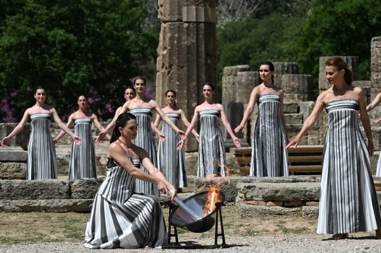Greek actress Mary Mina, playing the role of the High Priestess, lights the torch during the rehearsal of the flame lighting ceremony (Aris MESSINIS)