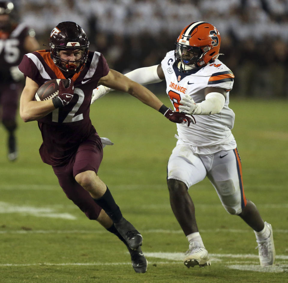 Virginia Tech wide receiver Stephen Gosnell (12) runs while chased by Syracuse defender Marlowe Wax (2) during the second half of an NCAA college football game Thursday, Oct. 26, 2023, in Blacksburg, Va. (Matt Gentry/The Roanoke Times via AP)