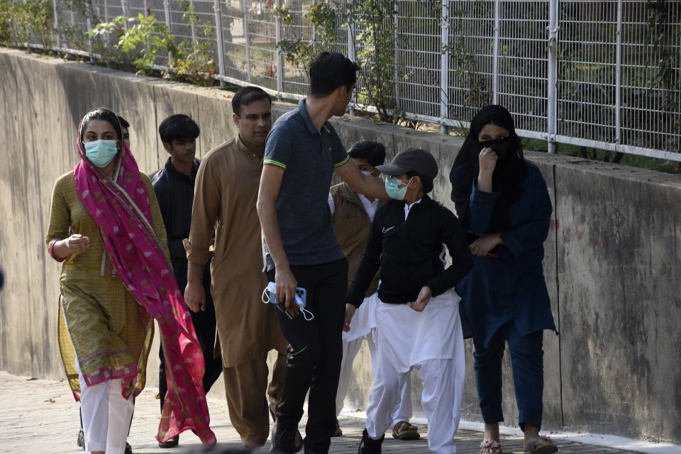 Family members and relatives of a senior Pakistani slain journalist Arshad Sharif walks back after glimpsing his remains at a hospital, in Islamabad, Pakistan, Wednesday, Oct. 26, 2022. A plane carrying the body of Sharif who was shot and killed by Nairobi police while living in hiding in Kenya touched down at an airport in Islamabad just after midnight Wednesday, officials said. (AP Photo/W.K. Yousufzai)