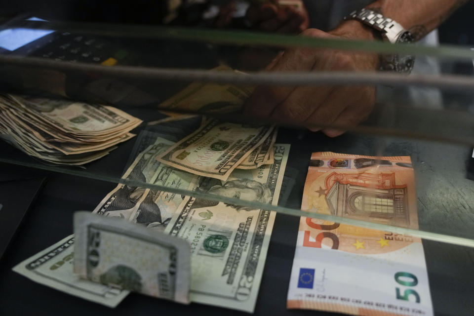 A cashier changes a 50 Euro banknote with US dollars at an exchange counter in Rome, Wednesday, July 13, 2022. The euro on Tuesday fell to parity with the dollar for the first time in nearly 20 years. (AP Photo/Gregorio Borgia)