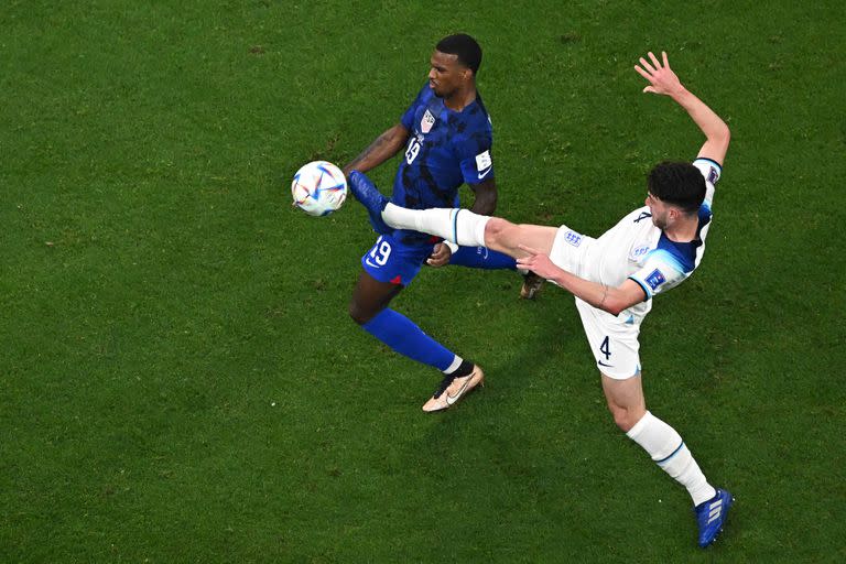 USA's forward #19 Haji Wright (L) fights for the ball with England's midfielder #04 Declan Rice during the Qatar 2022 World Cup Group B football match between England and USA at the Al-Bayt Stadium in Al Khor, north of Doha on November 25, 2022. (Photo by MANAN VATSYAYANA / AFP)