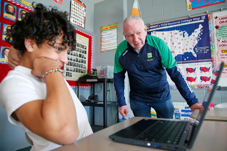 Christopher Donnelly, originally from Derry, Northern Ireland, gives Jonathan Reyes a hand during his social studies class at the Normandin Middle School in New Bedford.