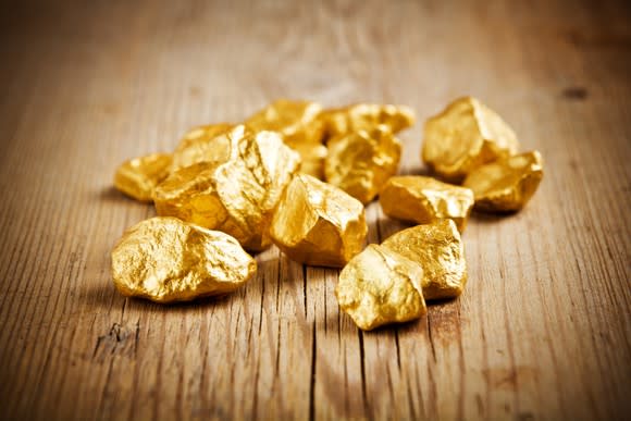 Gold nuggets on a wooden table.