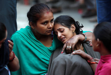 A woman is consoled as she mourns the death of a relative after a commuter train traveling at high speed ran through a crowd of people on the rail tracks on Friday, outside a hospital in Amritsar, India, October 20, 2018. REUTERS/Adnan Abidi