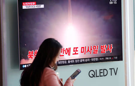 A woman walks past a television broadcast of a news report on North Korea firing what appeared to be an intercontinental ballistic missile (ICBM) that landed close to Japan, in Seoul, South Korea, November 29, 2017. REUTERS/Kim Hong-Ji