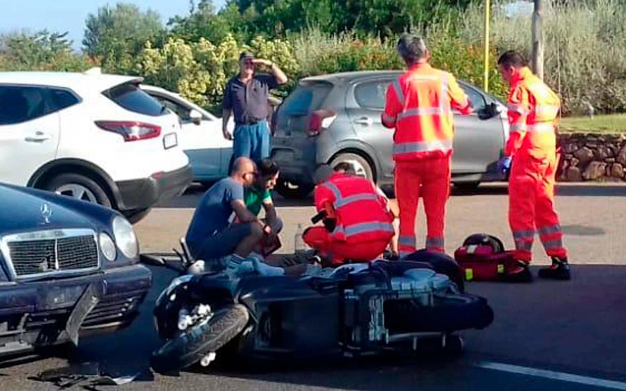 Ambulance personnel tend to a man lying on the ground, later identified as actor George Clooney, after the accident near Olbia in Sardinia - AP