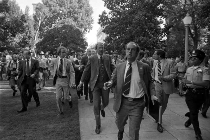 Secret Service agents rush President Gerald R. Ford toward the California State Capitol following an attempt on the president's life by Lynette "Squeaky" Fromme -- a disciple of Charles Manson -- on September 5, 1975, in Sacramento, Calif. Fromme escaped from prison on December 23, 1987. File Photo courtesy Gerald R. Ford Library