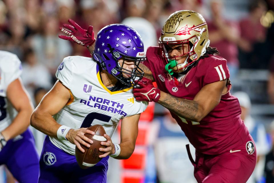 North Alabama quarterback Noah Walters is grabbed by Florida State defensive lineman Patrick Payton during the first half of an NCAA college football game Saturday, Nov. 18, 2023, in Tallahassee, Fla. (AP Photo/Colin Hackley)