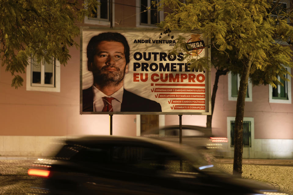 Cars drive past an election campaign poster of Andre Ventura, leader of the populist party Chega, in Lisbon, Wednesday, Jan. 19, 2022. Portuguese voters go to the polls Sunday, two years earlier than scheduled after a political crisis over a blocked spending bill brought down the country's minority Socialist government and triggered a snap election. (AP Photo/Armando Franca)