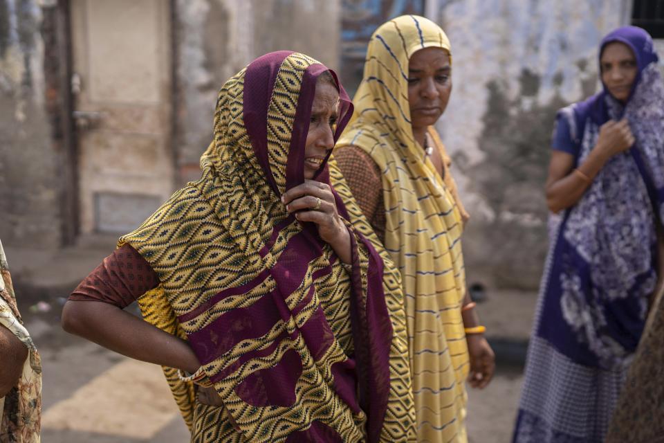 Relatives of Yash Devadana 12, Raj Baghwanji Bhai, 13, who died in abridge collapse, mourn outside their house in Morbi town of western state Gujarat, India, Tuesday, Nov. 1, 2022. On Sunday evening, the two cousins were seen leaving for the bridge hand in hand. By midnight, they were both dead, perished in the very waters they loved to swim in. (AP Photo/Rafiq Maqbool)