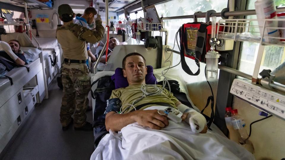 Inside the medical evacuation bus, 'Liahk,' an accountant who was mobilized in April and sent to the front a month ago, recovers after surviving a drone attack on the tank he was was in while on the front line in the Donetsk region. 