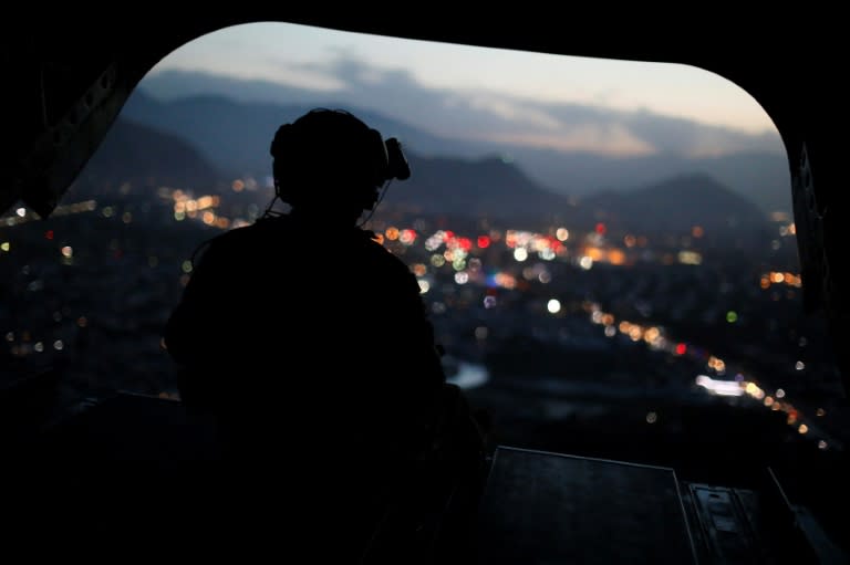 A US Army serviceman sits at the tailgate of an helicopter. The Afghan Taliban announce the start of their "spring offensive", saying they would target foreign forces in their country