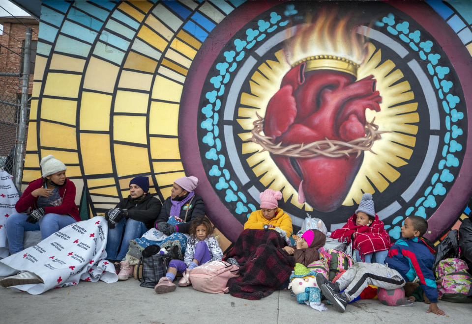 Migrants try to stay warm while camping outside the Sacred Heart Church in El Paso, Texas, on Sunday, Dec. 18, 2022. Growing numbers of migrants suffer violence that amounts to torture on their journeys. Doctors, social workers, clergy and shelter directors say they’re arriving at the US-Mexican border in desperate need for trauma-informed medical and mental health treatment. (AP Photo/Andres Leighton)