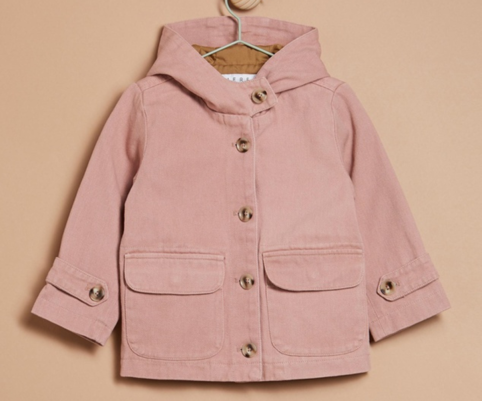 A pastel pink kids twill jacket sits on a pale orange background.