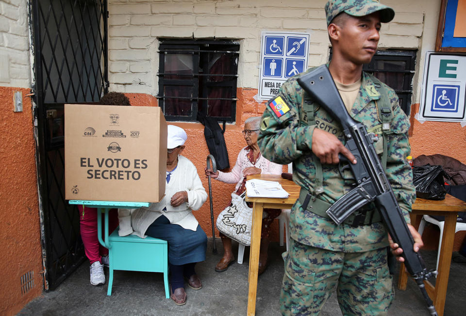 <p>A woman casts her vote as a soldier stands guard at a school-turned-polling station during the presidential election in Quito, Ecuador on Feb. 19, 2017. (Photo: Mariana Bazo/Reuters) </p>