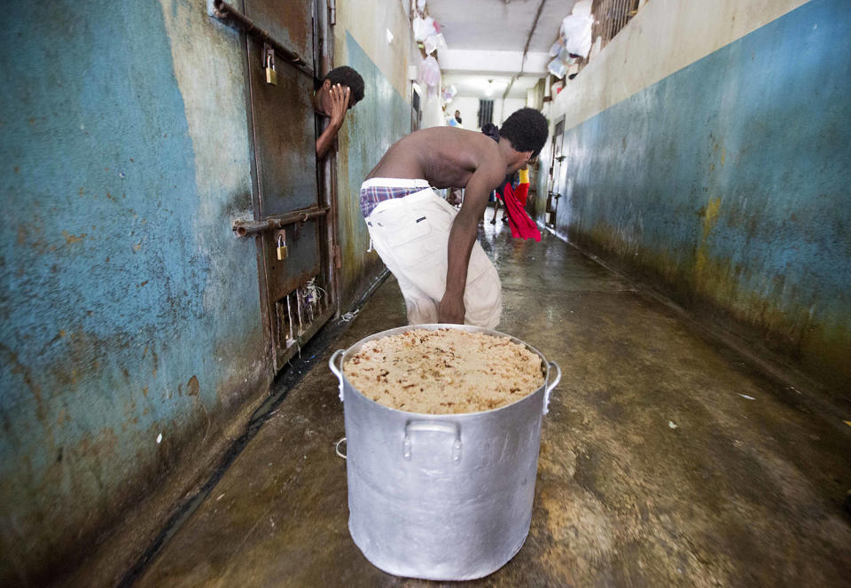 <p>A prisoner pulls a large stock pot filled with rice and beans during lunch inside the National Penitentiary in downtown Port-au-Prince, Hait, Feb. 13, 2017i. Prison authorities say they try their best to meet inmates’ needs, but repeatedly receive insufficient funds from the state to buy food and cooking fuel, leading to deadly cases of malnutrition-related ailments such as beriberi and anemia. (Photo: Dieu Nalio Chery/AP) </p>