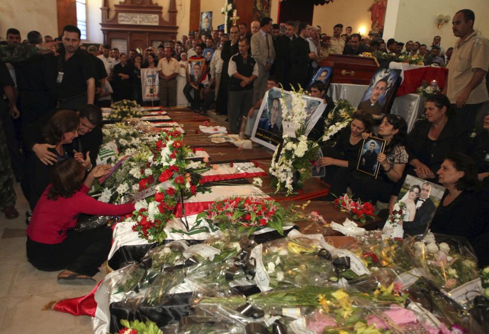 FILE - In this Tuesday, Nov. 2, 2010 file photo, relatives grieve near the coffins of slain Christians at a funeral mass in Baghdad, Iraq. The victims were killed Sunday when gunmen stormed a church during mass and took the entire congregation hostage. Iraq was estimated to have more than 1 million Christians before the 2003 U.S.-led invasion that toppled dictator Saddam Hussein. Now, church officials estimate only few hundred remain within Iraq borders. The rest are scattered across the globe, resettling in far-flung places like Australia, Canada and Sweden as well as neighboring countries. (AP Photo/Khalid Mohammed, File)