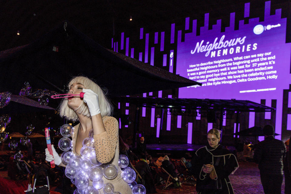 Fans react during a screening of the final episode of Australian TV soap, Neighbours, at Federation Square in Melbourne, Australia, Thursday, July 28, 2022. After 37 years the final episode of Australia's longest-running TV show was broadcast in Australia. (Diego Fedele/AAP via AP)