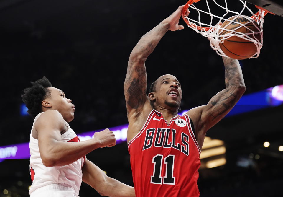 Chicago Bulls forward DeMar DeRozan (11) scores past Toronto Raptors forward Scottie Barnes during the first half of an NBA basketball game Tuesday, Feb. 28, 2023, in Toronto. (Frank Gunn/The Canadian Press via AP)