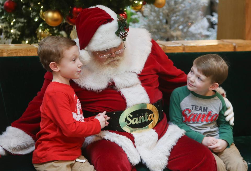 Nathan Rainey, 5, left, talks to Santa Claus as he and his brother, Noah, 4, sit beside Santa to have a photo made at University Mall in Tuscaloosa on Thursday, Dec. 21, 2017.    [Staff Photo/Erin Nelson]