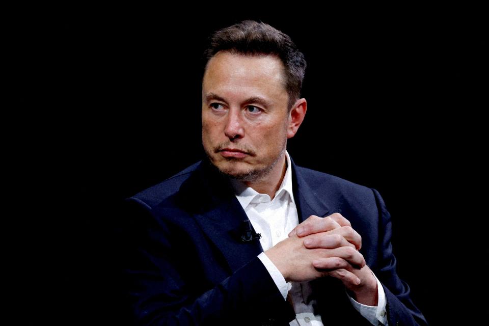 Elon Musk clasping his hands.
