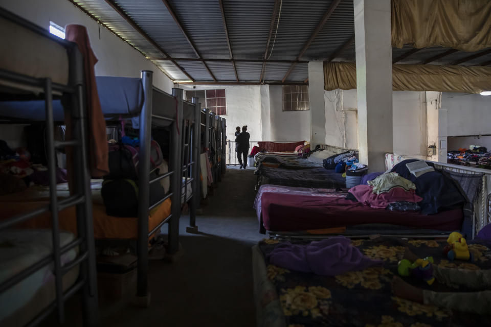 A migrant carries a child inside the "Embajadores de Jesus" Christian migrant shelter in Tijuana, Mexico, Tuesday, Sept. 26, 2023. While many places in Mexico provide shelter for migrants from other countries, some shelters in Tijuana have seen an influx of Mexicans fleeing violence, extortion and threats by organized crime. (AP Photo/Karen Castaneda)