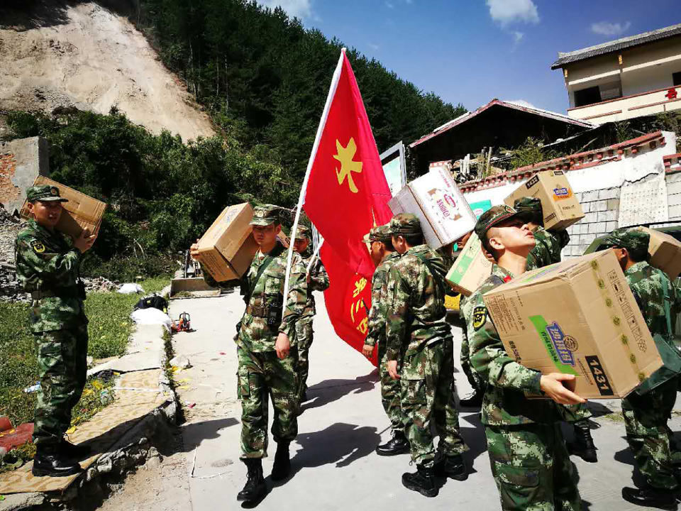 <p>Chinese paramilitary police carry relief supplies on their way to an earthquake-stricken zone in Jiuzhaigou in China’s southwestern Sichuan province on Aug. 9, 2017. (Photo: STR/AFP/Getty Images) </p>