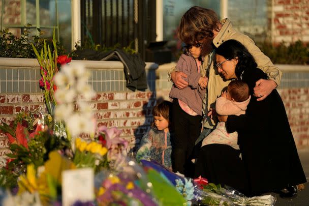 PHOTO: A family gathers at a memorial outside the Star Ballroom Dance Studio, Jan. 24, 2023, in Monterey Park, Calif. (Ashley Landis/AP)