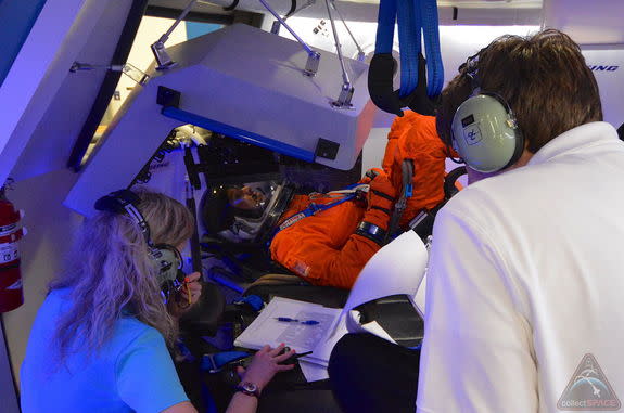 NASA astronaut Randy Bresnik, wearing a shuttle-era Advanced Crew Escape Suit (ACES) pressure suit, takes part in a fit check inside Boeing's CST-100 space capsule mockup, July 22, 2013.