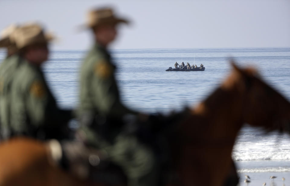 United States Border Patrol agents mounted on horseback look on as a boat with agents sits offshore near the border with Tijuana, Mexico, before a visit by Secretary of Homeland Security Kirstjen Nielsen Tuesday, Nov. 20, 2018, in San Diego. Nielsen said Tuesday an appeal will be filed on the decision by a judge to bar the Trump administration from refusing asylum to migrants who cross the southern border illegally. (AP Photo/Gregory Bull)