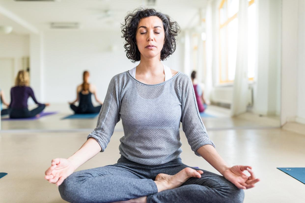 middle-aged woman meditating in gym class