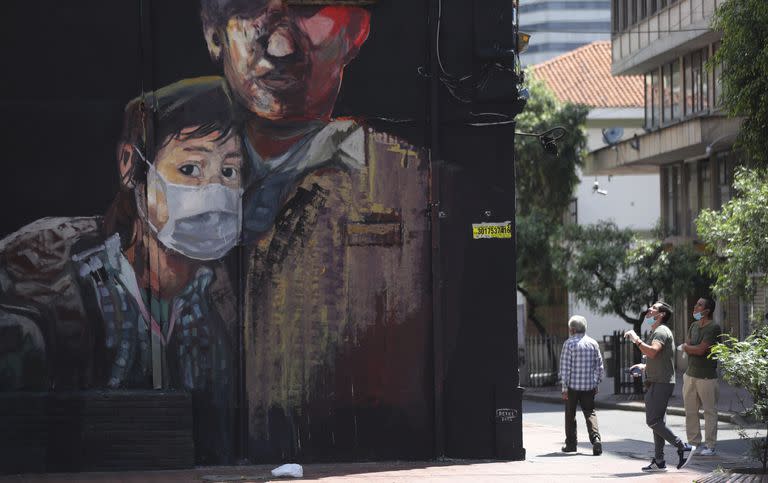 Un mural muestra a una joven con un barbijo en Bogotá, el lunes 13 de abril de 2020. Hay coincidencia en que el gobierno de Duque tuvo una buena política de vacunación nacional, pero una mala respuesta de asistencia a los sectores más afectados