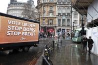 A vehicle brandishing an election campaign poster for the Liberal Democrats party, drives in Trafalgar Square in London, Tuesday, Dec. 10, 2019. Britain goes to the polls on Thursday, Dec. 12. (AP Photo/Thanassis Stavrakis)